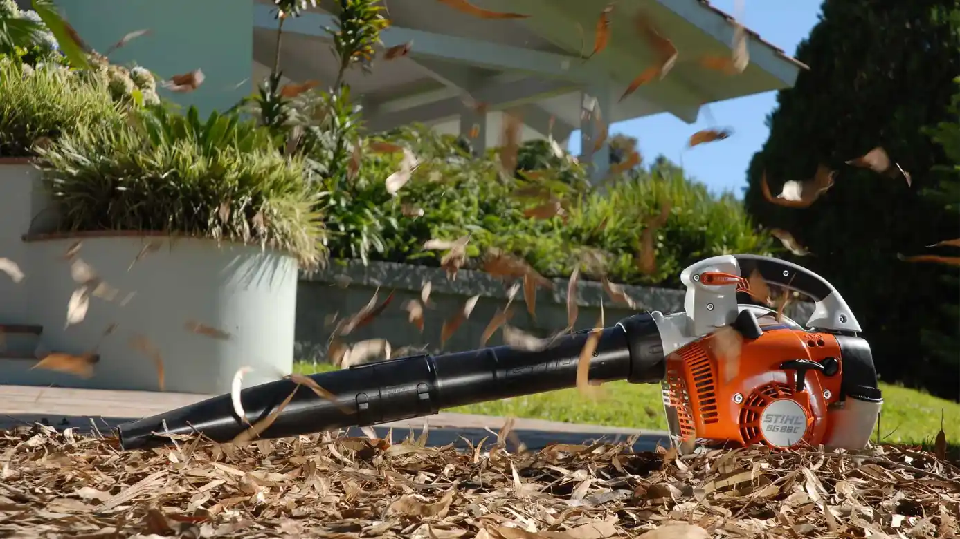 Soprador Stihl recolhendo folhas secas em um jardim residencial